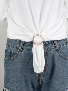 Detail eines runden Perlen-T-Shirt-Knotens an weißem Baumwollshirt mit Denim-Shorts