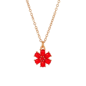 Detail of gold chain necklace with red six-petal flower pendant and center zircon