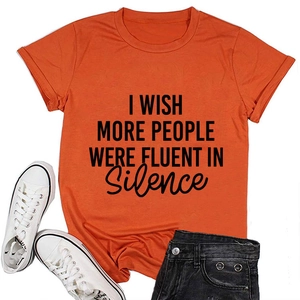 T-shirt orange vif à col rond avec texte noir imprimé posé à plat avec un short en jean