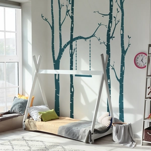 Detail of white wooden teepee bed frame with decorative birch forest wall stickers