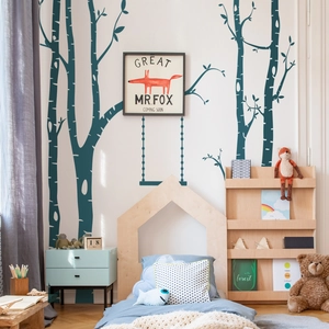 Detail of Nordic wall stickers showing dark teal birch trees and a fox swing on a wall