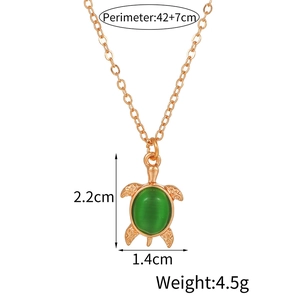 Detailed view of turtle pendant with green opal stone and adjustable gold chain necklace