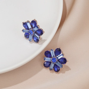 Detailed macro view of dark blue crystal flower stud earrings with rose gold plating