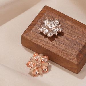 Detailed close-up of champagne crystal flower earrings with gold-plated alloy base