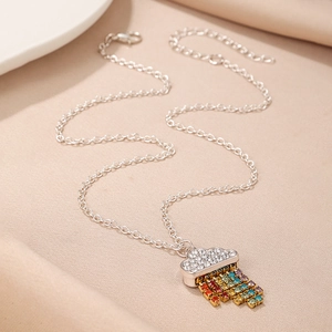 Macro detail of silver cloud necklace pendant with colorful rainbow rhinestone tassels