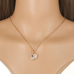 Macro view of gold heart pendant necklace with shimmering crystal pavé stones