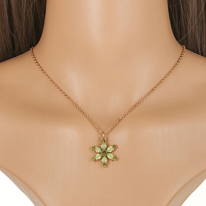 Close-up of rose gold flower pendant with green pear-shaped crystals on necklace