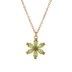 Detailed macro view of the rose gold necklace with flower pendant and green crystals