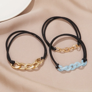Three-piece hair tie set with gold and translucent blue chains on beige silk fabric