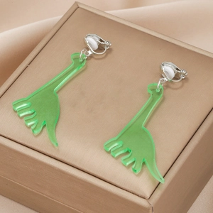 Fluorescent green acrylic dinosaur clip-on earrings for kids on a gold jewelry box