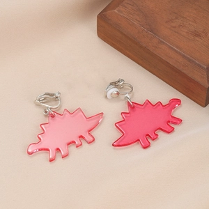 Close-up of translucent red acrylic stegosaurus clip-on earrings with metal fastener