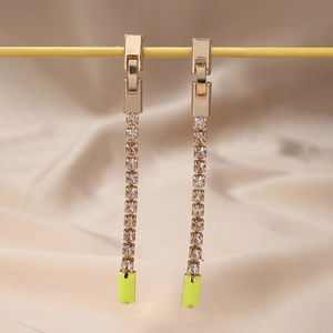 Détail de pendentifs rectangulaires jaune néon avec franges en strass sur boucles dorées