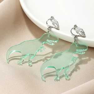 Macro detail of cute green acrylic T-Rex dinosaur clip-on earrings for kids and women