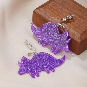 Close-up of cute purple glitter acrylic triceratops clip-on earrings on display