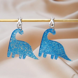 Creative blue glitter acrylic dinosaur clip-on earrings on a gold display stand