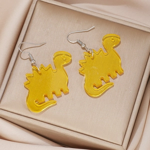 Detail view of yellow acrylic stegosaurus earrings on elegant champagne satin