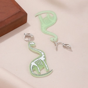 Detail of green acrylic dinosaur skeleton clip-on earrings on a textured background