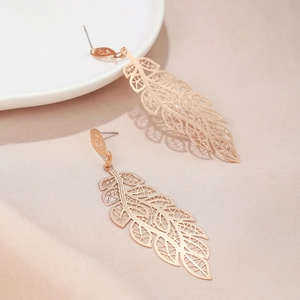 Detailed view of rose gold leaf earrings with delicate hollow vein texture on silk