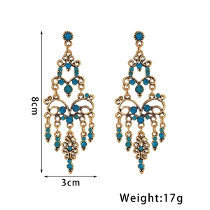 Details van vintage boheemse kroonluchter oorbellen in antiek goud met blauwe steen