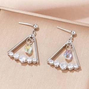 Macro detail of geometric silver earrings with teardrop zircon and AB coating finish