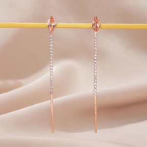 Macro detail of long tassel flower earrings with marquise champagne zircon in rose gold
