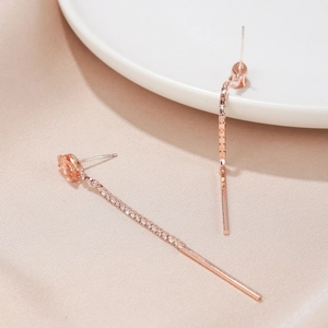 Detail shot of long rose gold tassel earrings with champagne pear-cut stones and crystals