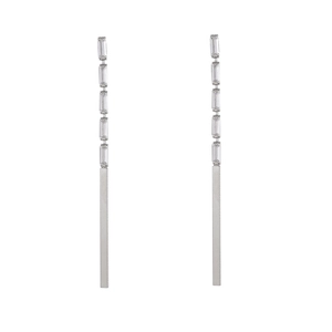Close-up of silver dangle earrings with rectangular cubic zirconia and metal tassels