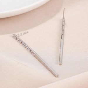 Detailed view of silver flower tassel earrings with rectangular baguette-cut cubic zirconia