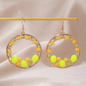 Boucles d'oreilles bohèmes dorées avec perles jaunes et cristaux sur fond de soie douce