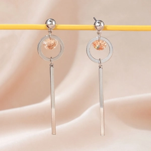 Detail view of silver flower earrings with long bar tassel and champagne cubic zirconia