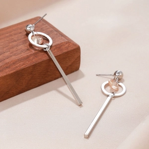 Macro shot of silver tassel earrings with champagne zircon flower and long metal bar