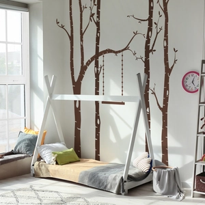 Detail view of dark brown birch tree and swing wall stickers in a cozy nursery bedroom