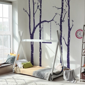 Detailed view of tree and swing wall stickers near a Nordic style wooden kids bed frame