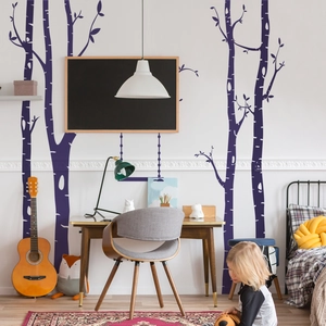 Detail of minimalist purple birch tree wall stickers in a cozy nursery room setting