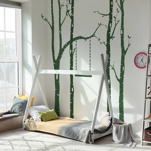 Detailed view of forest tree wall decals with swing in a cozy sunlit bedroom