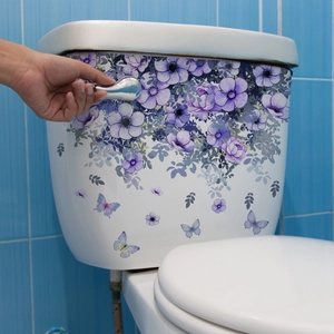 Waterproof purple flower and butterfly toilet stickers on a white ceramic tank surface