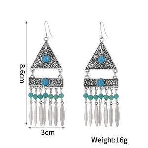 Bohemian silver tassel earrings with turquoise beads and leaf charms on white background