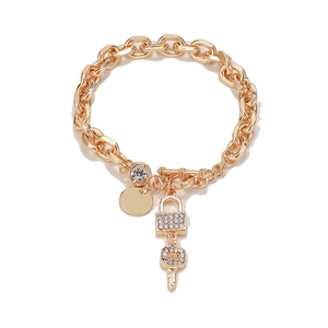 Detail of gold chain bracelet with OT buckle, rhinestone lock and key charms