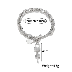 Close-up of silver toggle clasp bracelet with pavé crystal lock and key charms