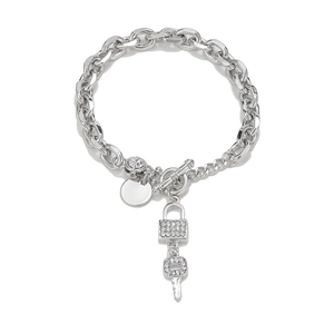 Detail shot of silver link bracelet featuring crystal lock and key charms with toggle clasp