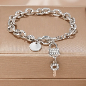 Silver chunky chain bracelet with sparkling lock and key charms on a jewelry box