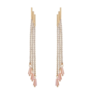 Close-up of long tassel earrings with sparkling rhinestones and pink floral drops