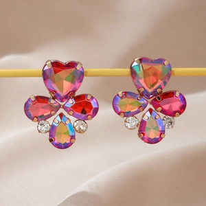 Détail macro des boucles d'oreilles bohèmes en forme de cœur avec gemmes multicolores