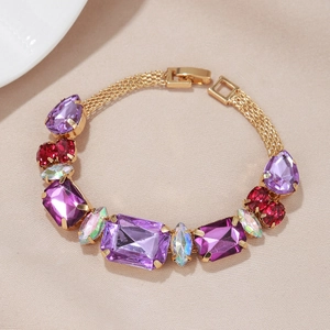 Détail d'un bracelet doré vintage orné de grandes pierres violettes et bordeaux