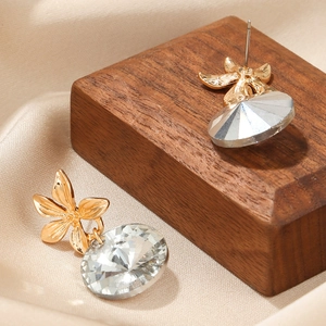 Elegant gold flower crystal drop earrings on premium silk and wood background