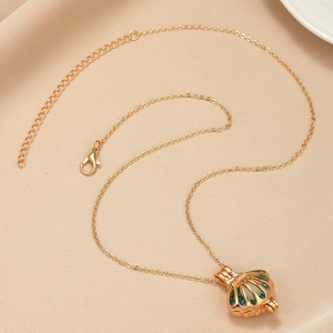 Detail of gold shell pendant necklace with blue zircon accents and inner pearl bead