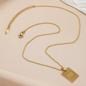 Minimalist gold necklace with rectangular MORE LOVE pendant and elegant bead chain