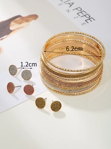 Detail of 10 layered gold bangles and 3 pairs of glitter earrings with 6.2cm diameter