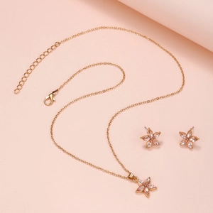 Star jewelry set including a gold pendant necklace and earrings with pink gemstones