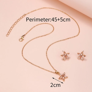 Gold star flower jewelry set with necklace and earrings on a pink background